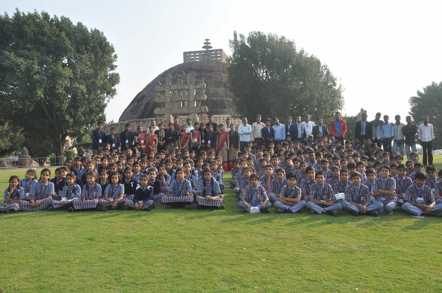 ACS Boda students seated in front of a heritage stupa during an educational visit